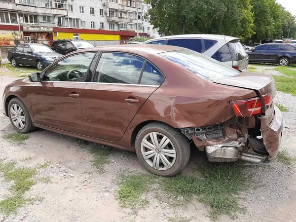 Brown sedan with damage to the rear quarter panel and bumper