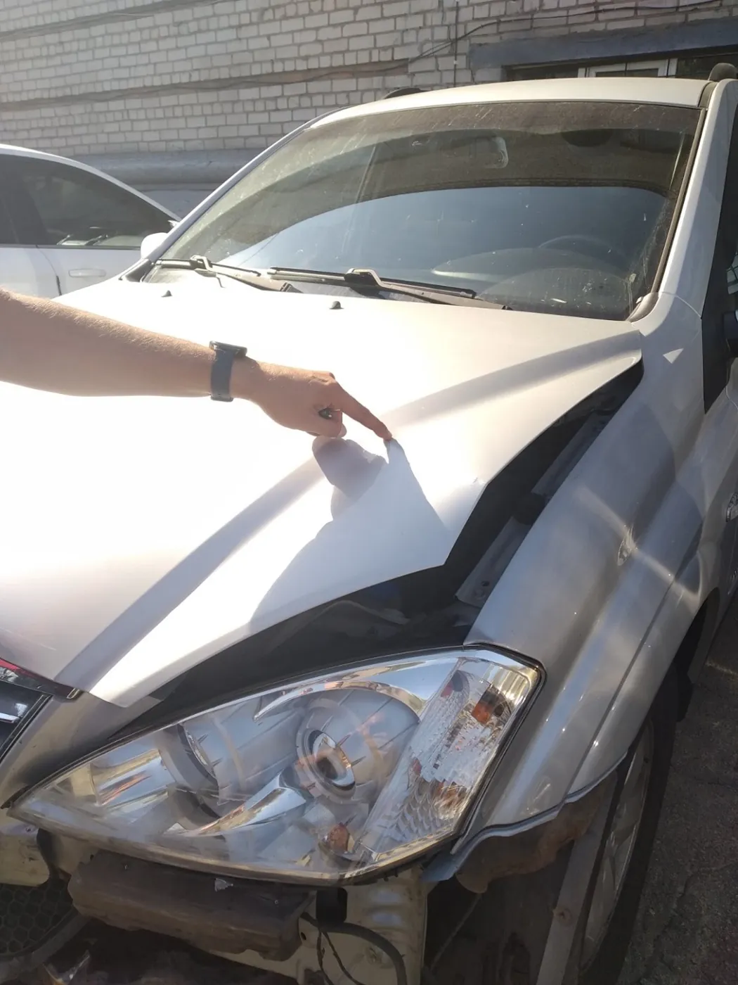 Пошкоджений капот сріблястого авто