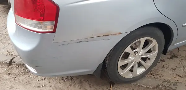 Silver hatchback with damage to the rear bumper and quarter panel