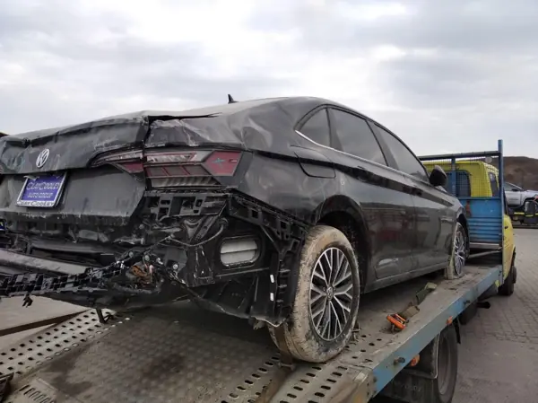 Dark sedan with rear body damage, side view