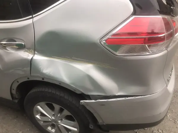 Damage to the rear quarter panel of a grey car